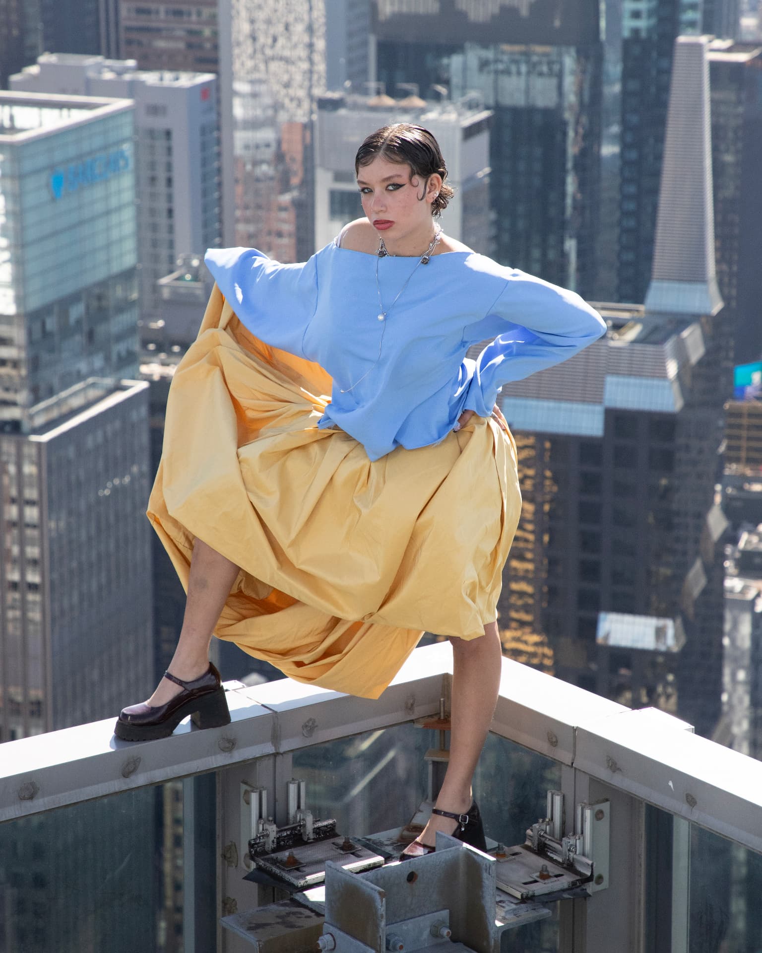 eonic blue top and yellow skirt above the manhattan skyline